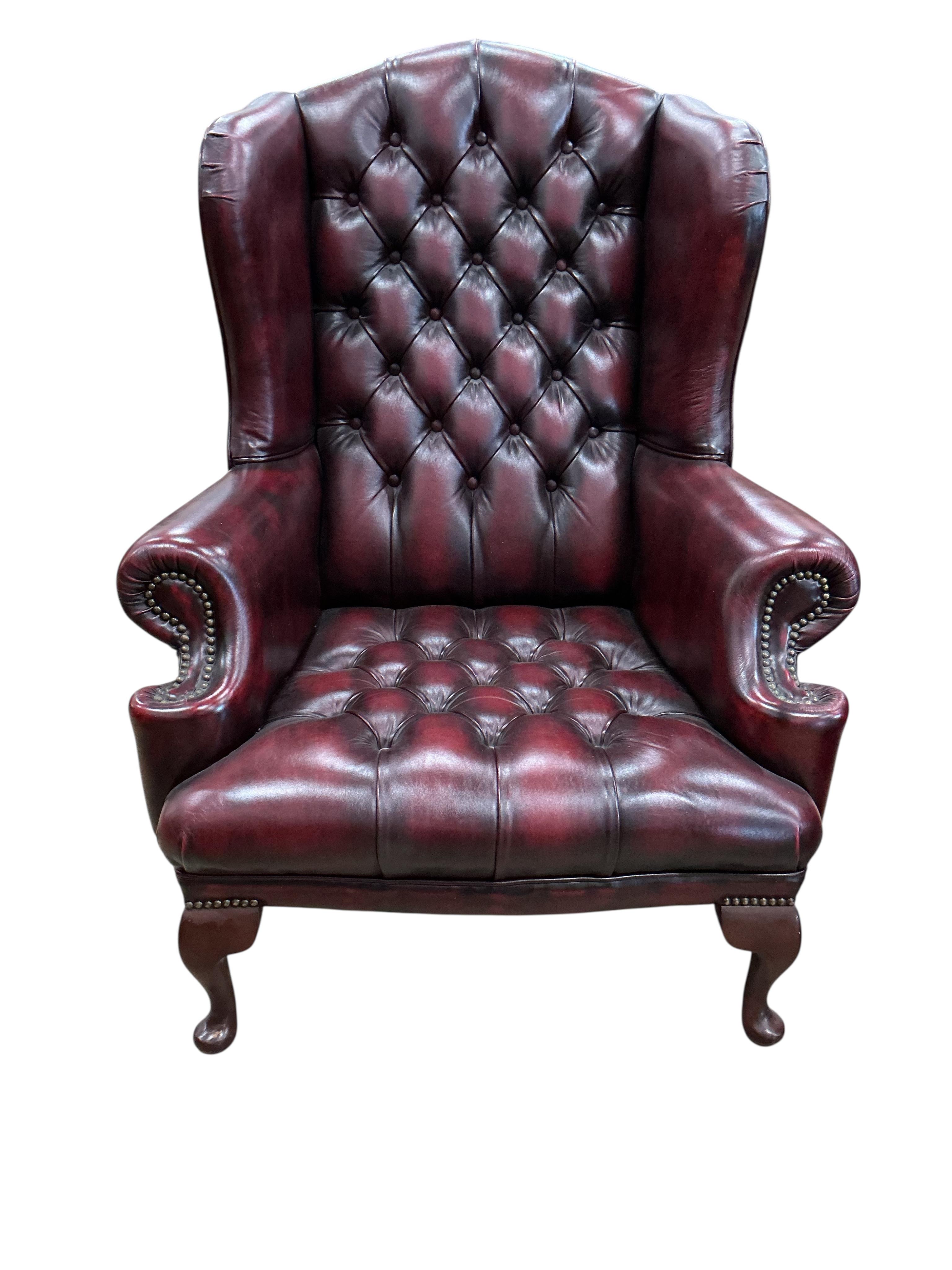 A pair of reproduction buttoned burgundy leather wing armchairs, width 82cm, depth 70cm, height 104cm